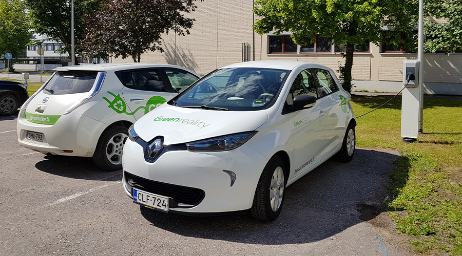 Kaksi valkoista Renault-sähköautoa, joissa vihreät Lappeenrannan kaupungin Green Reality -teippaukset.