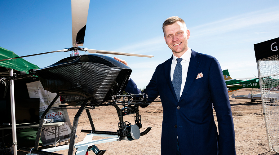 Pyhtään kunnanjohtaja Jouni Eho poseeraa dronen vieressä Pyhtään lentokentällä.