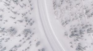 Aerial photo of snowy road in a forest