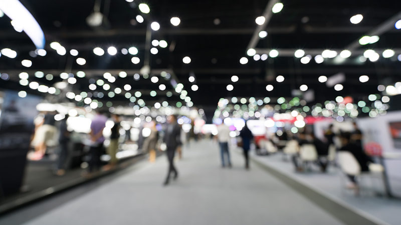 Blurred, defocused background of public exhibition hall. Business tradeshow or stock market, organization or company event, commercial trading fair, or shopping mall marketing advertisement concept