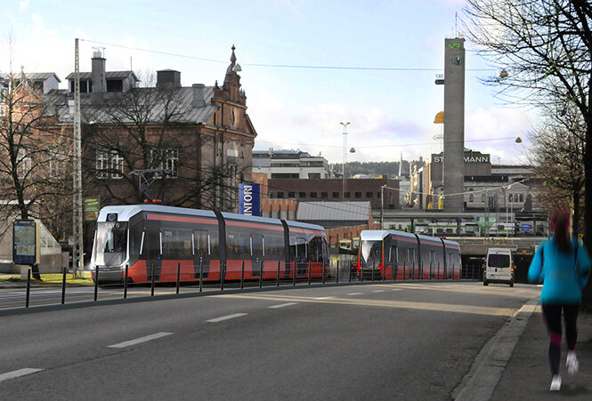 Kuvassa näkyy Tampereen punainen raitiovaunu liikenteessä kaupungin keskustassa.