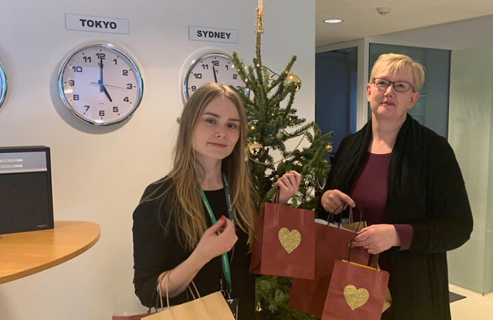 Kuvassa kaksi Kuntarahoituksen työntekijää pitävät käsissään lahjapaketteja, jotka henkilökunta on lahjoittanut hyväntekeväisyyskeräykseen.