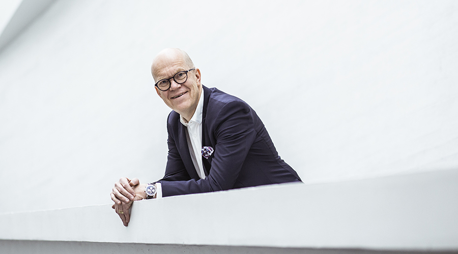 Kuvassa Kuntarahoituksen toimitusjohtaja Esa Kallio nojaa parvekekaiteeseen ja hymyilee kameralle.