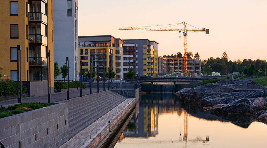 Kuvituskuva, jossa on rakenteilla olevia kerrostaloja kaupunkimaisemassa.
