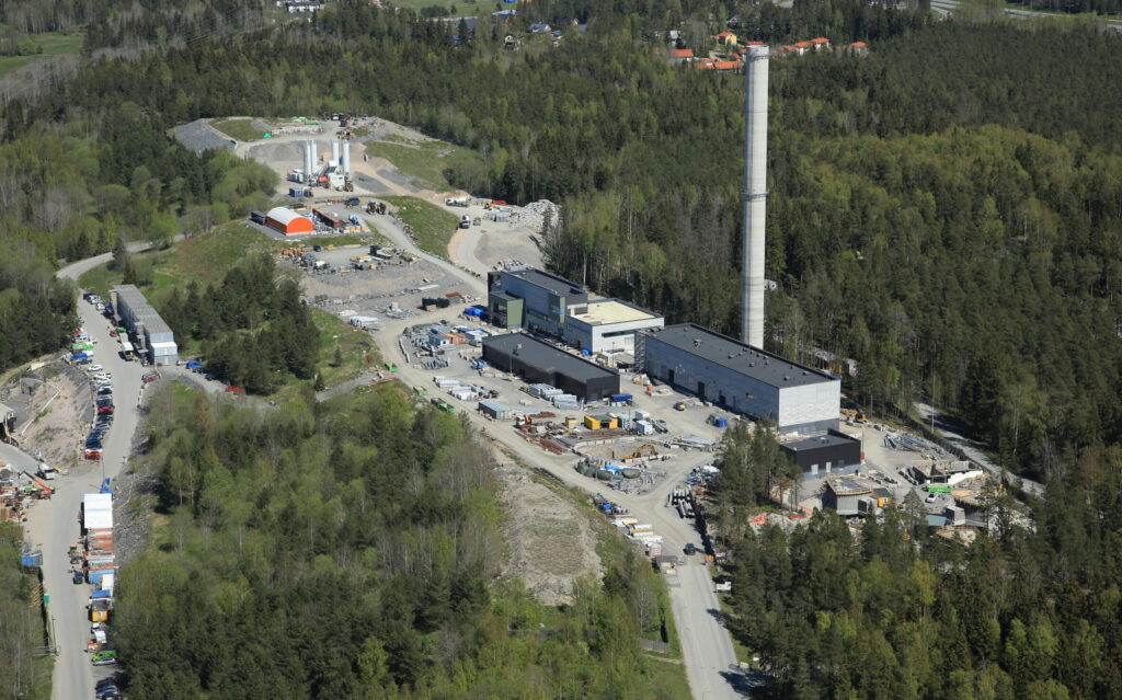Kuvassa on jätevedenpuhdistamo ilmasta kuvattuna metsämaiseman keskellä.