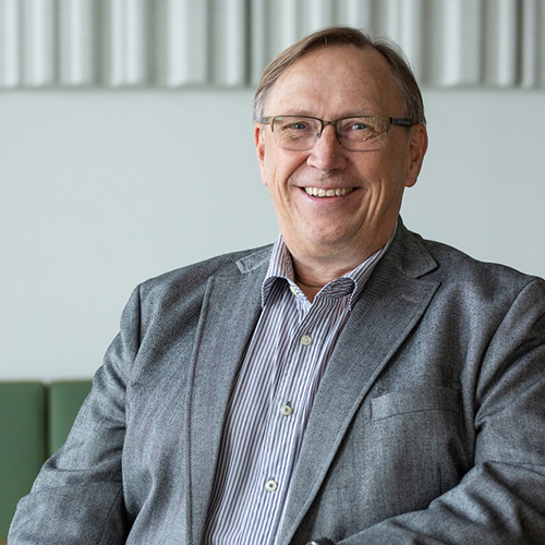 Matti Kokkinen hymyilee harmaa puku päällä.