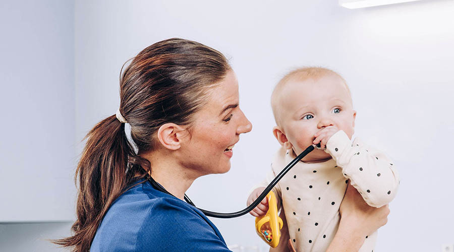 A nurse holding a baby in a hospital