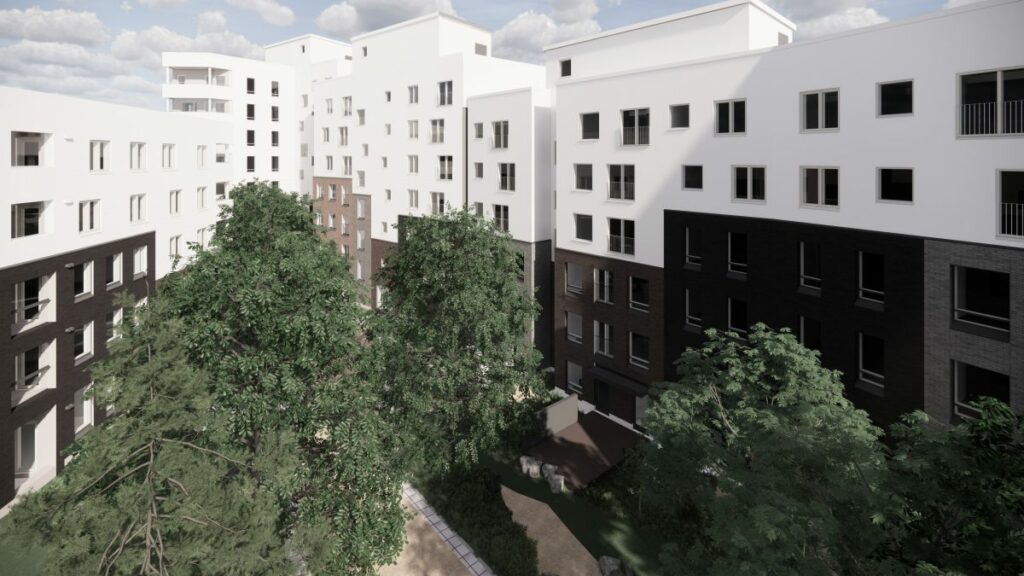 Kuvassa on ison kerrostalon sisäpiha, jossa kasvaa puita.