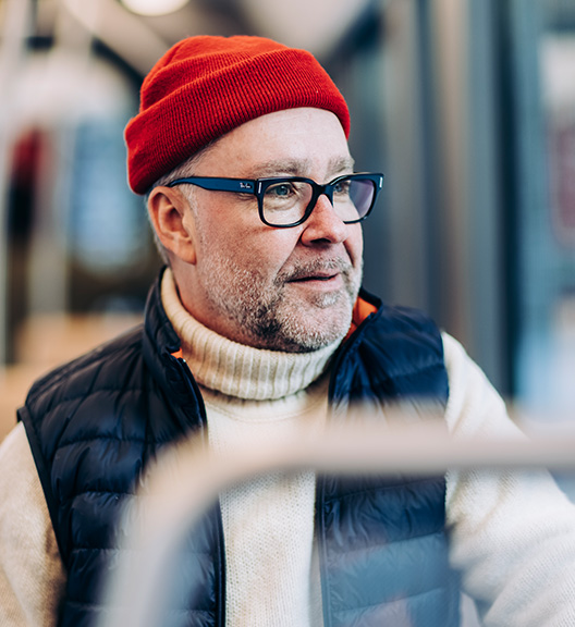 Punapiponen henkilö matkustaa ratikalla.