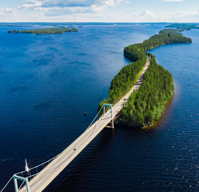 Tuulimyllyjä suomalaisessa järvimaisemassa.