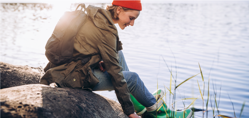 A young person is sitting in nature by seaside.