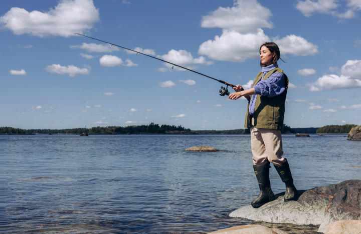 A person fishing on a rock.