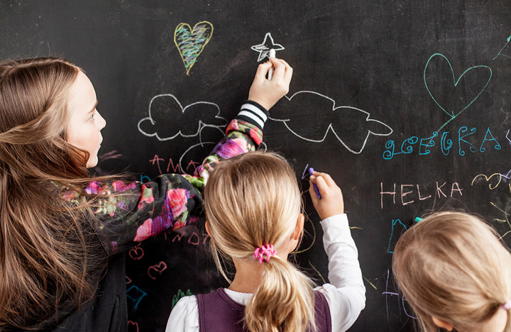 Children drawing on a blackboard.