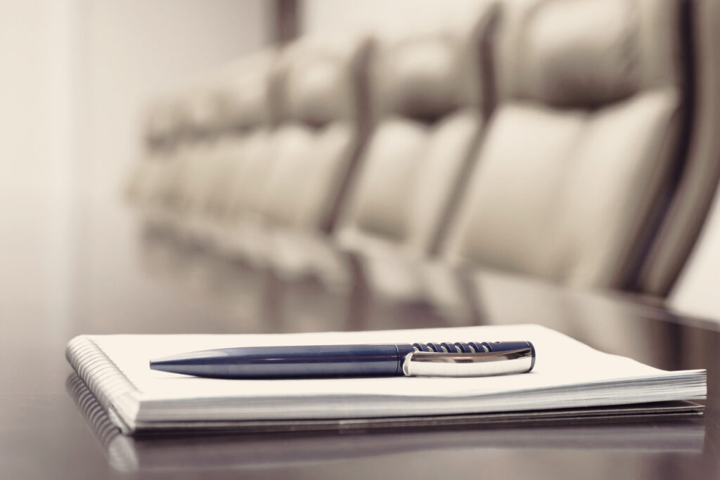 Closeup of notepad kept on table in empty conference room