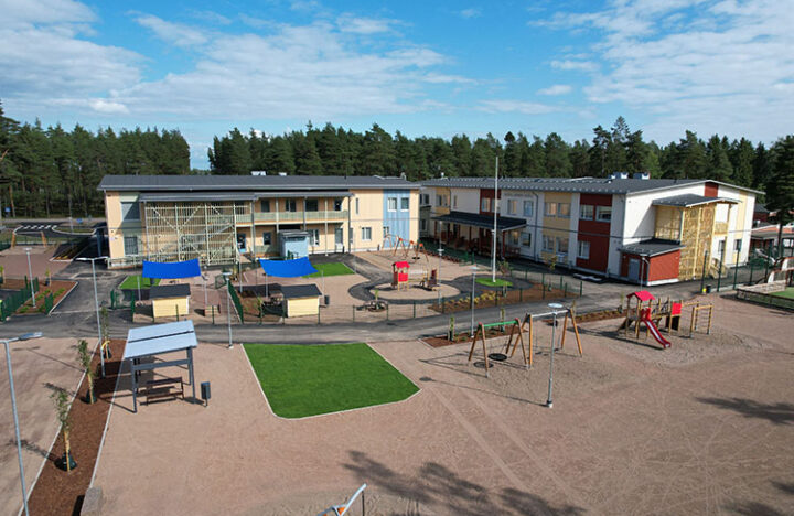 Koulu, päiväkoti ja niiden edustalla piha leikkipaikkoineen