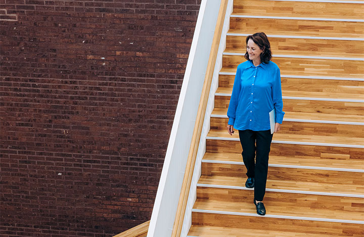 A person walking down wooden stairs.