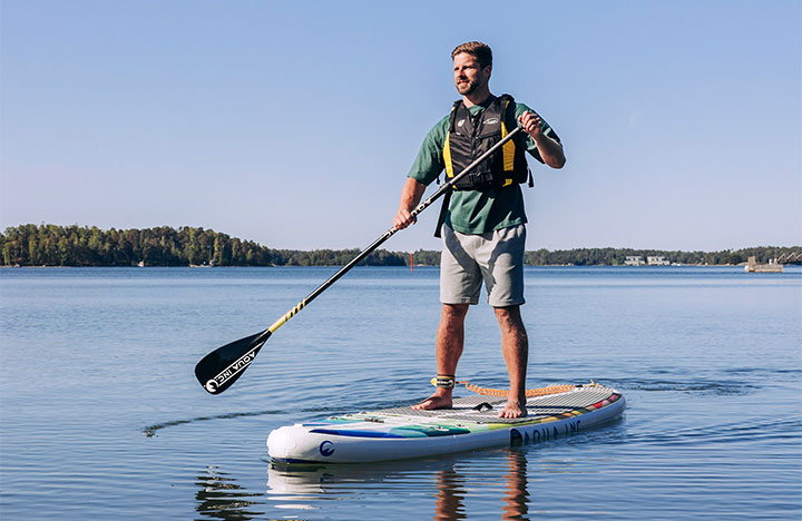 Sup-lautaileva henkilö suomalaisessa merimaisemassa.
