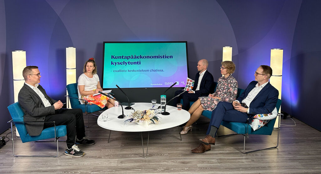 Panelistit pöydän ääressä.