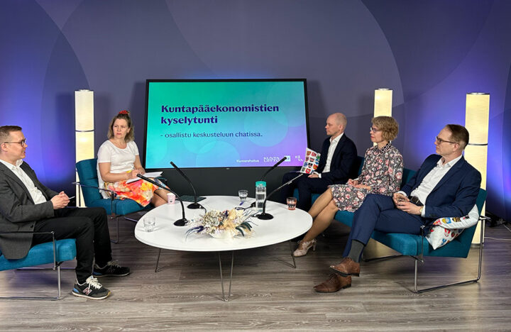 Panelistit pöydän ääressä.