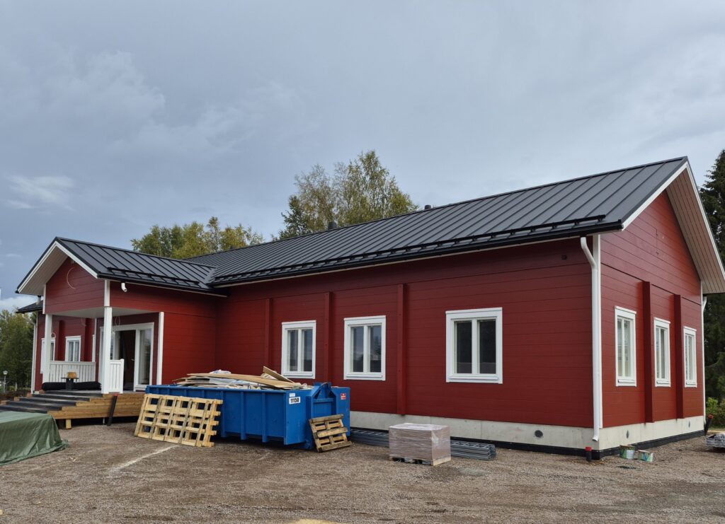 Halsuan uusi kunnantalo ja päiväkoti. Punainen, vielä rakenteilla oleva mutta lähes valmis yksikerroksinen hirsitalo.